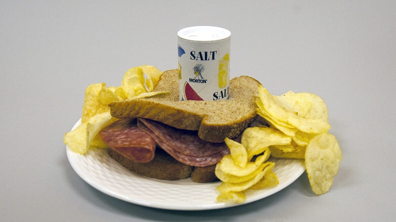 This photo illustration shows a salt shaker in a plate with a sandwich and potato chips in Miami on Tuesday, Feb. 7, 2012. (AP Photo/Wilfredo Lee, J Pat Carter)