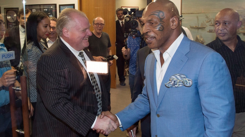 Toronto Mayor Rob Ford, centre, shakes hands with former heavyweight boxing champion Mike Tyson at City Hall in Toronto on Tuesday, Sept. 9, 2014. (Darren Calabrese / THE CANADIAN PRESS)