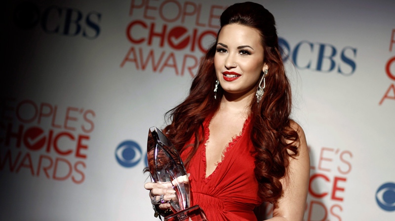 Demi Lovato poses backstage with the award for favorite pop artist at the People's Choice Awards in Los Angeles, Wednesday, Jan. 11, 2012. (AP / Matt Sayles)