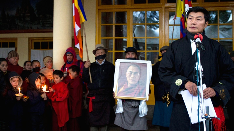 Lobsang Sangay, right, Prime Minister of the Tibetan government-in-exile, stands next to a portrait of the Dalai Lama as he speaks after a prayer session to remember Tibetans who have died in Tibet and as a show of solidarity for those living in Tibet, in Dharmsala, India, Wednesday, Feb. 8, 2011. (AP / Ashwini Bhatia)