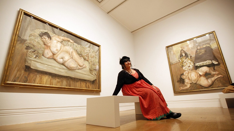 Sue Tilley a model for British painter Lucian Freud poses for the media in front of a painting of her by Freud at an exhibition of his paintings at the National Portrait Gallery in London, Wednesday, Feb. 8, 2012. (AP Photo/Alastair Grant)