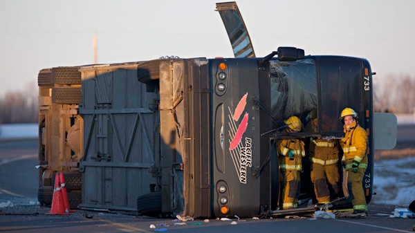 Firefighters and crews investigate after a bus rolled over on on Highway 28 near Redwater, about 65 kilometres northeast of Edmonton on Friday, Feb. 10, 2012. (Jordan Verlage / THE CANADIAN PRESS)