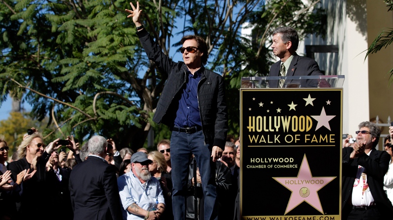 Paul McCartney, centre, waves as he is introduced by Leron Gubler, president and CEO of the Hollywood Chamber of Commerce, during a dedication ceremony for his star on the Hollywood Walk of Fame in Los Angeles, Thursday, Feb. 9, 2012. (AP / Jae C. Hong)