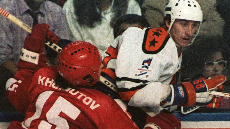 In this Feb.13, 1987 photo, Andrei Khomutov of the Soviet National Team takes out Wayne Gretzky of the NHL All-Stars during Rendez-vous 87, an exhibition hockey game in Quebec City. It was at the junction of sport and culture for canada, the U.S. and Russia. THE CANADIAN PRESS/Bill Grimshaw