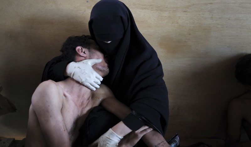 In this photo provided on Friday Feb. 10, 2012 by World Press Photo, the 2012 World Press Photo of the year by Samuel Aranda, Spain, for The New York Times, shows a woman holding a wounded relative during protests against president Saleh in Sanaa, Yemen, Oct. 15, 2011.