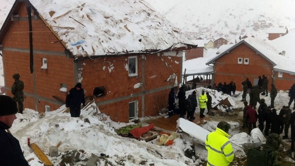 Bodies of two avalanche victims are placed near the house and covered with blankets after an avalanche hit houses in the village in Restelica, southern Kosovo, Sunday, Feb. 12, 2012. (AP)