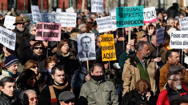 People hold banners reading 'Universal Justice here', 'What a shame', among others, during a protest in support of judge Garzon in Madrid, Spain, Sunday, Feb. 12, 2012. (AP / Andres Kudacki)