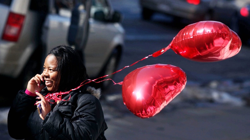 MATC nursing student Tonya Cox, outside the downtown Madison campus, holds heart-shaped balloons given to her by a friend and talks on her cell phone on Valentine's Day, Monday, Feb. 14, 2011, in Madison, Wis.