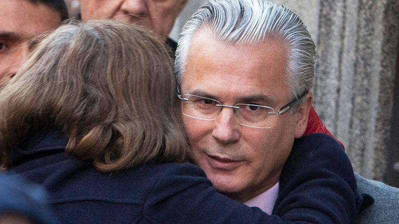 In this Jan. 31, 2012 file photo, an unidentified woman embraces Spanish judge Baltazar Garzon as he arrives at the Supreme Court in Madrid.