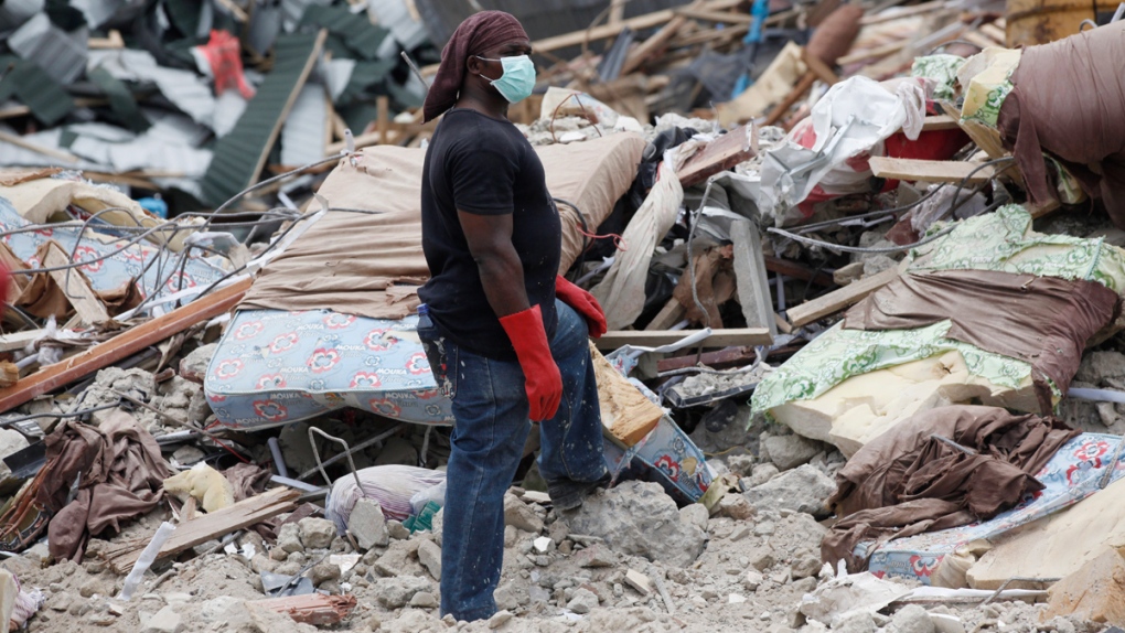 Rescue worker searches building rubble in Nigeria