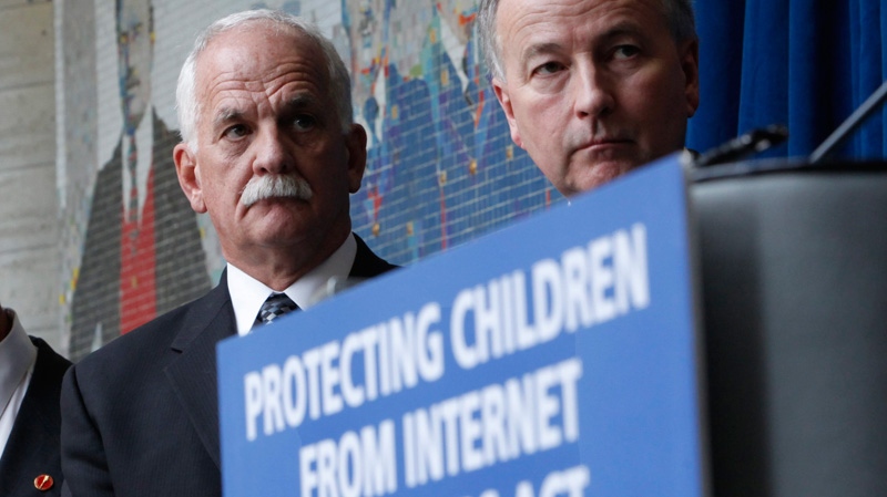 Public Safety Minister Vic Toews (left)and Justice Minister Rob Nicholson take part in a news conference to announce measures protecting children from internet predators, in Ottawa, Tuesday, Feb. 14, 2012. (Fred Chartrand / THE CANADIAN PRESS)