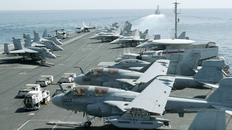 A picture taken from the bridge of the Nimitz-class aircraft carrier USS Abraham Lincoln shows U.S. aircraft parked on the flight deck as a U.S. destroyer, background, patrols the Arabian sea in the Strait of Hurmuz, Tuesday, Feb. 14, 2012. (AP / Hassan Ammar)