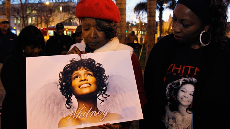 Whitney Houston fans, Lawanda Howkins, left, and Melanie Braggs honor her memory at a candlelight vigil in Leimert Park in Los Angeles on Monday, Feb. 13, 2012. (AP / Damian Dovarganes)