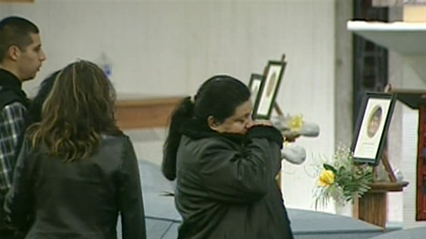 Mourners cry over the casket of a worker killed in a crash in Hampstead, Ont. during a memorial service, Wednesday, Feb. 15, 2012.