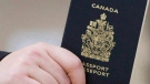 A passenger holds his Canadian passport before boarding a flight in Ottawa. (Tom Hanson / THE CANADIAN PRESS)