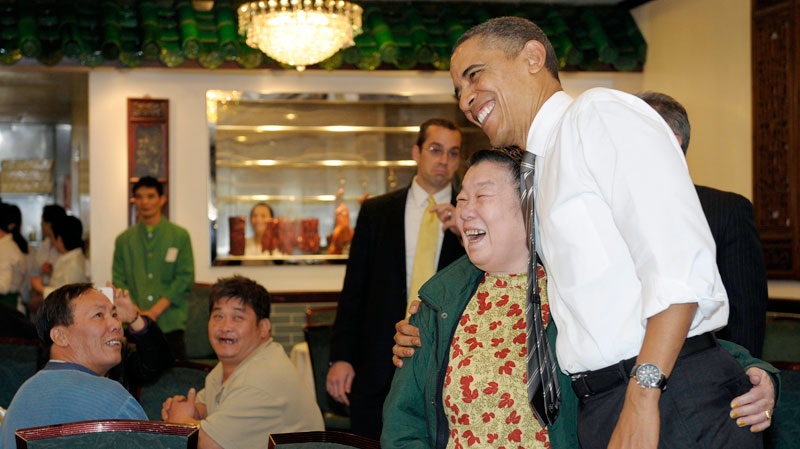 President Barack Obama greets the crowd as he waits for his Chinese food from Great Eastern Restaurant in San Francisco, Thursday, Feb. 16, 2012. (AP / Susan Walsh)