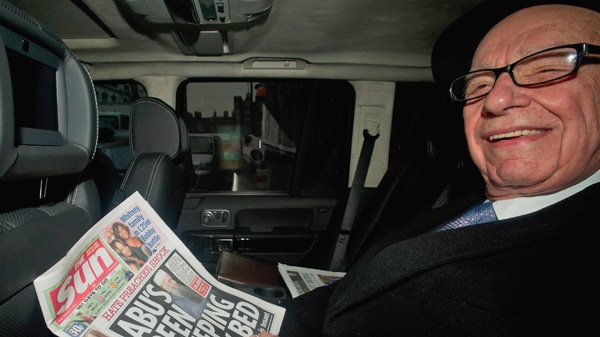 News Corp. chief executive Rupert Murdoch, reads his group's The Sun daily newspaper, as he is driven from his home, in central London, Friday, Feb. 17, 2012. (AP Photo)