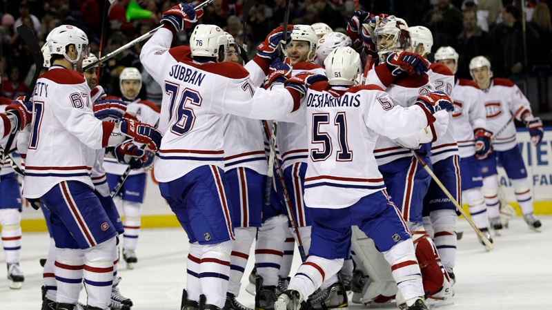 Montreal Canadiens' David Desharnais (51) celebrates with teammates after sealing the win with a shootout goal on Buffalo Sabres goalie Ryan Miller (not shown) after an NHL hockey game in Buffalo, N.Y., Friday, Feb. 17, 2012. The Canadiens won 4-3. (AP Photo/Devin Duprey)