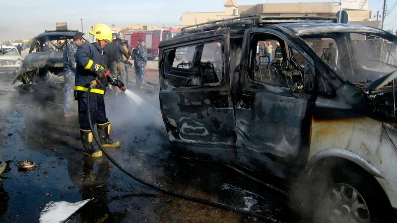 An Iraqi firefighter hoses down a burned bus after a car bomb attack in Kirkuk, 290 kilometers (180 miles) north of Baghdad, Iraq, Thursday, Feb. 23, 2012. (AP / Emad Matti)