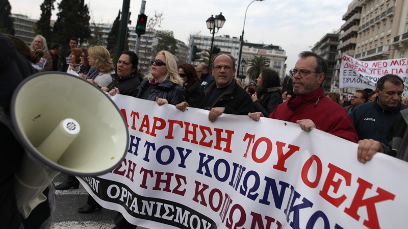 Employees at the state-run Workers' Housing Organization, OEK, chant slogans as they hold a banner witch reads 'do not close down the OEK' on Thursday, Feb. 23, 2012. (AP / Petros Giannakouris)