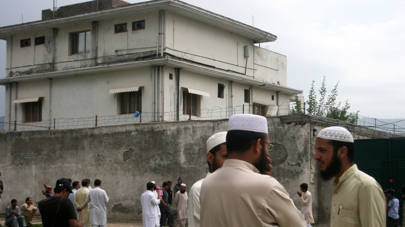 In this May 5, 2011 file photo, local residents and media are seen outside the house where al-Qaida leader Osama bin Laden was caught and killed in Abbottabad, Pakistan. 