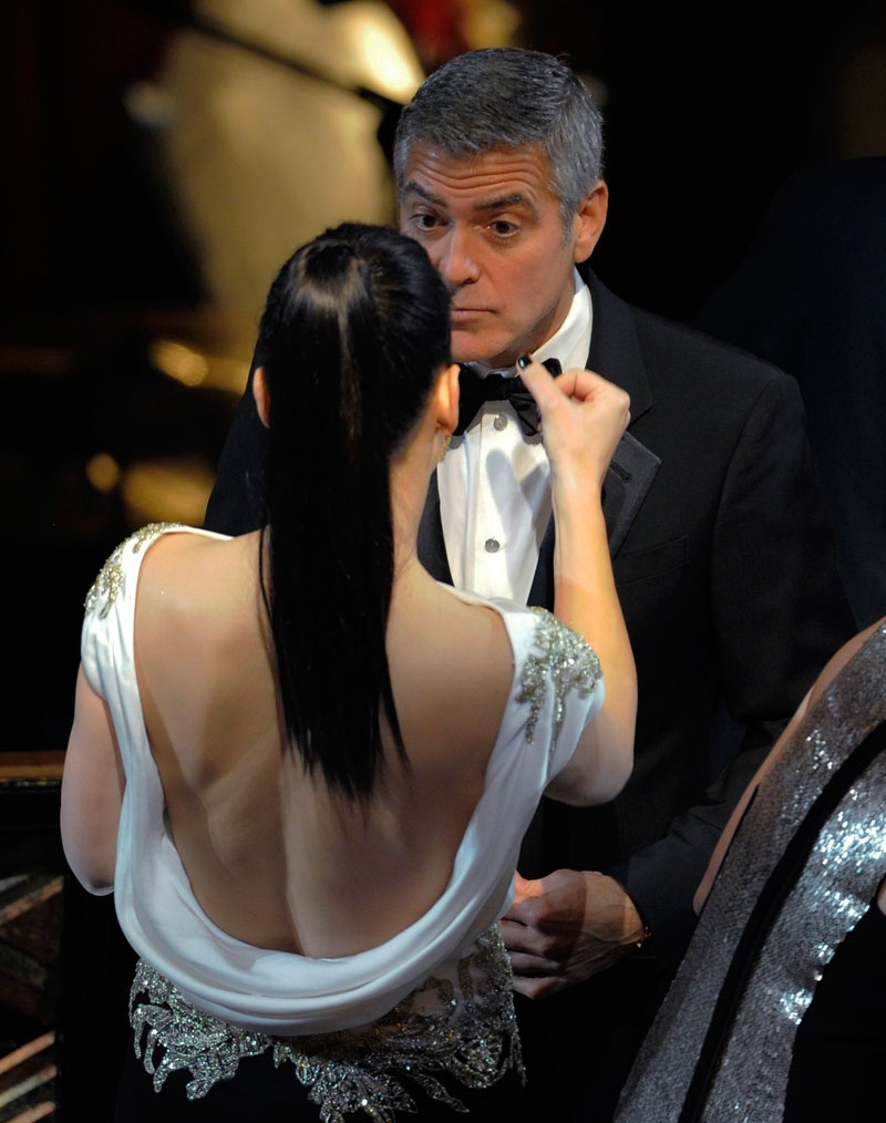 Sandra Bullock wipes the face of George Clooney before the 84th Academy Awards show on Sunday, Feb. 26, 2012, in the Hollywood section of Los Angeles. (AP Photo/Mark J. Terrill)