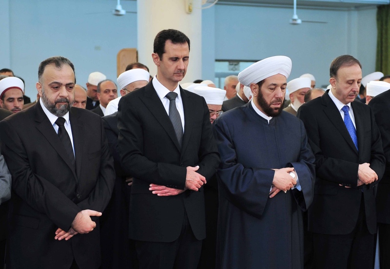 Syrian President Bashar Assad, second left, prays during Eid al-Adha prayer at a mosque in Damascus, Syria, on Saturday Oct. 4, 2014 in this photo released by the Syrian official news agency SANA. (Provided / SANA)