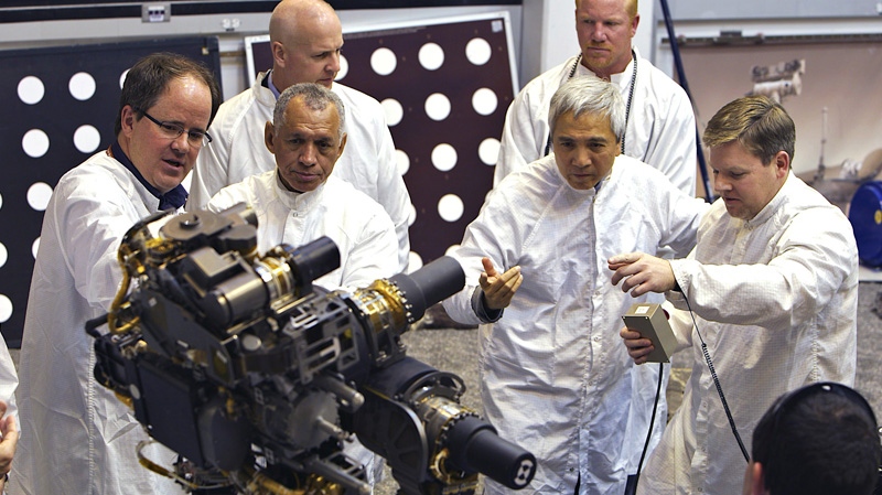 In this photo taken on Wednesday, Feb. 22, 2012, National Aeronautics and Space Administration, NASA administrator, Charles Bolden, second from left, examines a replica of the Mars Science Laboratory rover at NASA' Jet Propulsion Laboratory in Pasadena, Calif. Far left, Richard Cook, Deputy Project Manager Mars Science Lab Mission.  (AP Photo/Damian Dovarganes)
