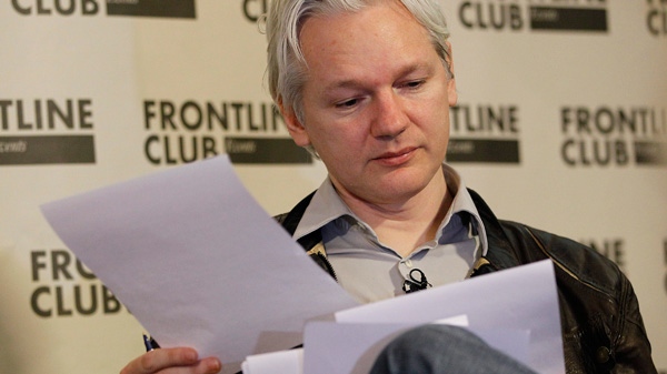 Julian Assange, founder of WikiLeaks looks at paperwork during a press conference in London, Monday, Feb. 27, 2012. (AP / Kirsty Wigglesworth)