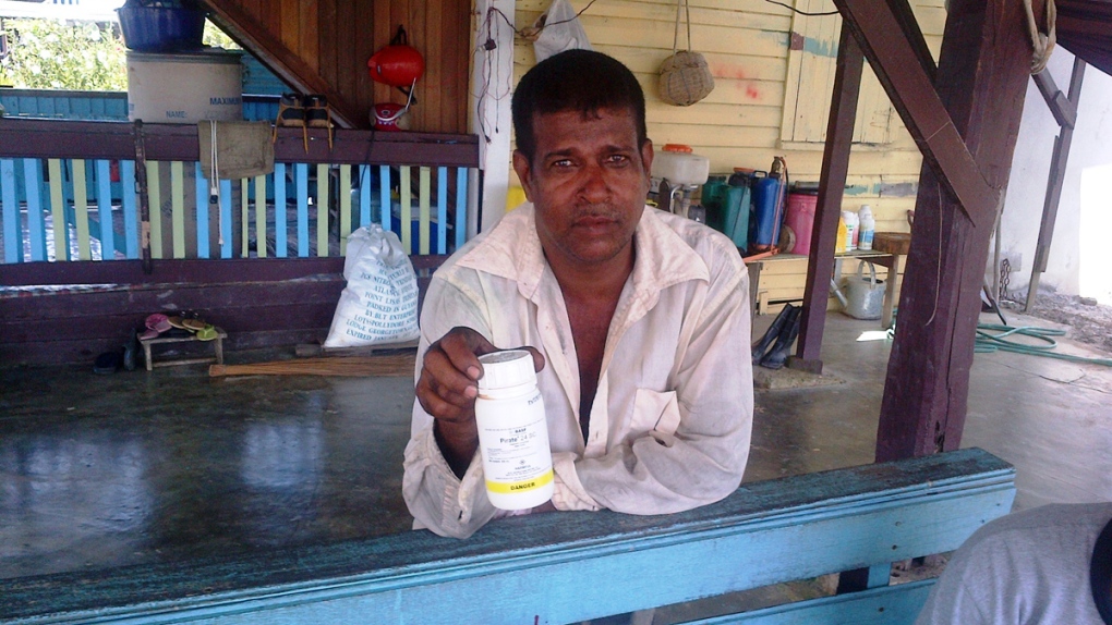 Vijai Ramlackhan holds a container of pesticide