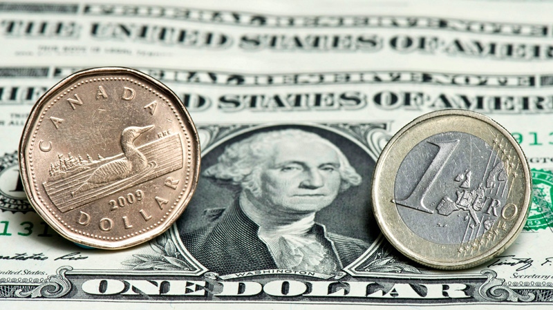 A Canadian dollar, left, and a Euro are seen next to a series of U.S. dollars. (Paul Chiasson / THE CANADIAN PRESS)