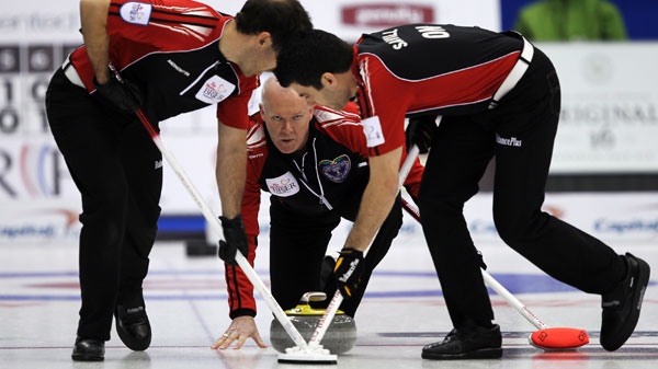 Ontario skip Glenn Howard, centre, watches his shot as second Brent Laing, left, and lead Craig Savill sweep during a morning draw against British Columbia at the Tim Hortons Brier in Saskatoon, Sask. Wednesday, March, 7, 2012. THE CANADIAN PRESS/Jonathan Hayward