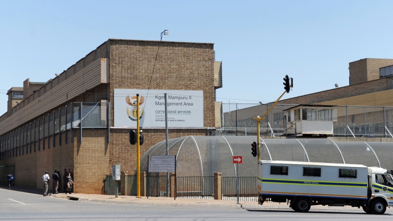 People walk outside the Kgosi Mampuru Correctional Services prison where Oscar Pistorius is being held in Pretoria, South Africa, Tuesday, Oct. 21, 2014. (AP)