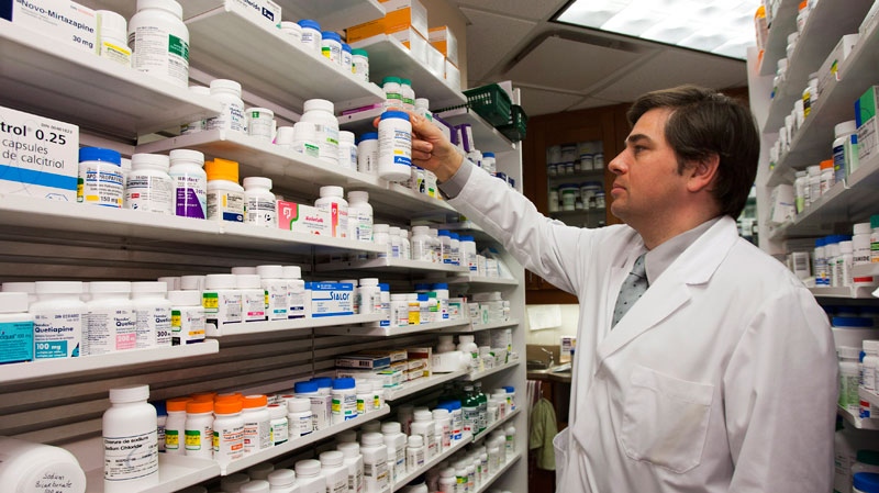 Pharmacist Denis Boissinot checks a bottle on a shelf at his pharmacy in Quebec City on Thursday, March 8, 2012. (Jacques Boissinot / THE CANADIAN PRESS)
