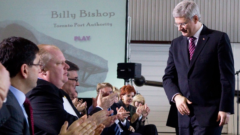 Prime Minister Stephen Harper is applauded by dignitaries and guests, including Toronto Mayor Rob Ford after delivering a speech to announce the construction of a pedestrian tunnel to Billy Bishop Airport in Toronto on Friday, March 9, 2012. (Chris Young / THE CANADIAN PRESS)