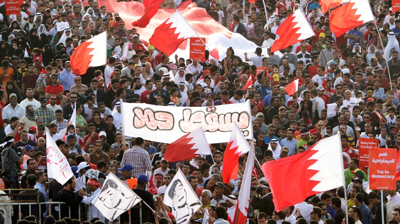 Thousands of Bahraini anti-government protesters carrying national flags and holding a banner that reads, "Down Hamad," referring to Bahrain's King, gather on a four-lane highway just outside Manama, Bahrain, Friday, March 9, 2012. (AP / Hasan Jamali)