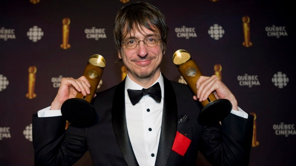Philippe Falardeau holds up his awards for best screenplay and best director for the movie Monsieur Lahzar at the Jutra awards, celebrating the Quebec film industry in Montreal, Sunday, March 11, 2012. (Graham Hughes / The Canadian Press)