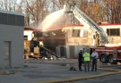 Firefighters continue to pour water on a building at Veolia ES Canada Industrial Services Inc. plant to prevent hot spots in Sarnia, Ontario following an explosion on Saturday Oct. 25, 2014. (THE CANADIAN PRESS/ Colin Graf)