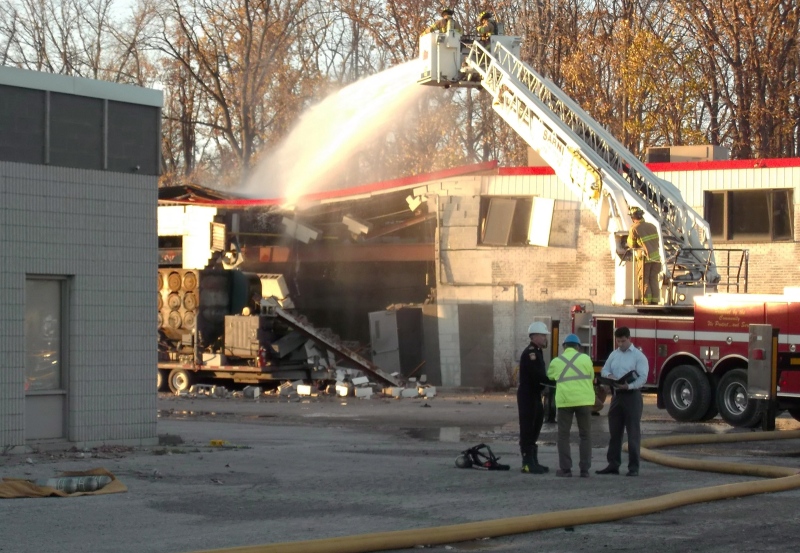 Firefighters continue to pour water on a building at Veolia ES Canada Industrial Services Inc. plant to prevent hot spots in Sarnia, Ontario following an explosion on Saturday Oct. 25, 2014. (THE CANADIAN PRESS/ Colin Graf)