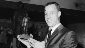 Detroit Red Wings' star Gordie Howe, wearing a prominent bruise over his right eye, compares miniature trophy he received with the large statue in New York, Feb. 20, 1967, after he received the Lester Patrick Memorial Trophy for long and meritorious service to the sport in the U.S. (AP / Dave Pickoff)
