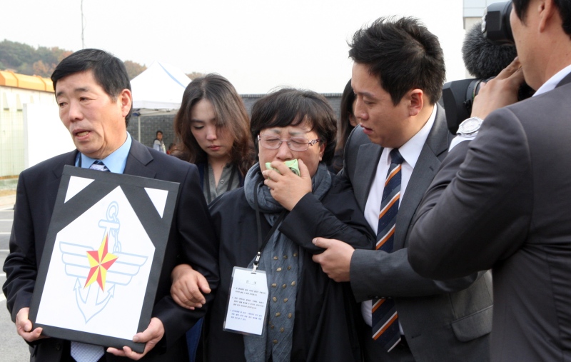 A mother, center, of a victim, identified as Private First Class Yoon, cries after the trial at an outside of military court in Yongin, south of Seoul, South Korea, Thursday, Oct. 30, 2014. (AP / Yonhap, Ryu Soo-hyun) 