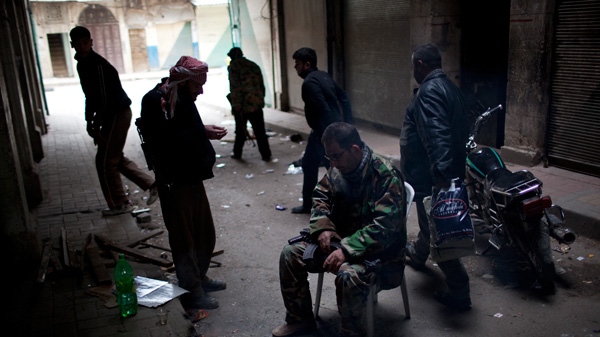 In this Sunday, March 11, 2012 file photo, Syria rebels pause for a moment in between fierce firefights with Syrian Army in the town of Idlib, north Syria. (AP / Rodrigo Abd, File)