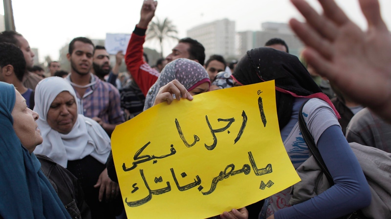 Egyptian activist Samira Ibrahim, centre holds a placard that reads in Arabic 'The people with the most manhood in Egypt are its women' while attending a rally with fellow activists chanting anti Military Supreme Council slogans during a protest in Tahrir square, Cairo, Egypt Tuesday, March 13, 2012.