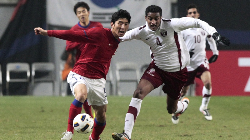 South Korea's Kim Dong-sub, left, fights for the ball with Qatar's Almahdi Ali Mukhtar during their Asian qualifying for the 2012 London Olympics in Seoul, South Korea, Wednesday, March 14, 2012. (AP Photo/Ahn Young-joon)