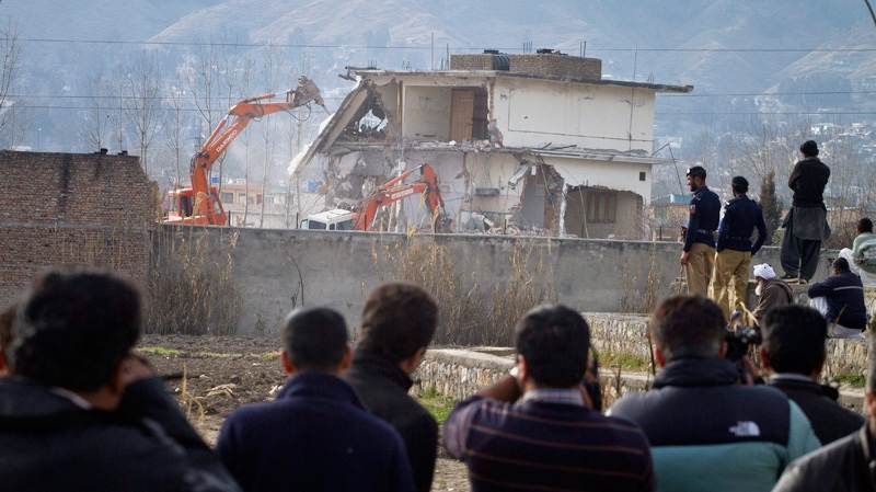 Pakistani media film as authorities use heavy machinery to demolish the compound of Osama bin Laden in Abbottabad, Pakistan on Sunday, Feb. 26, 2012. (AP / Anjum Naveed)
