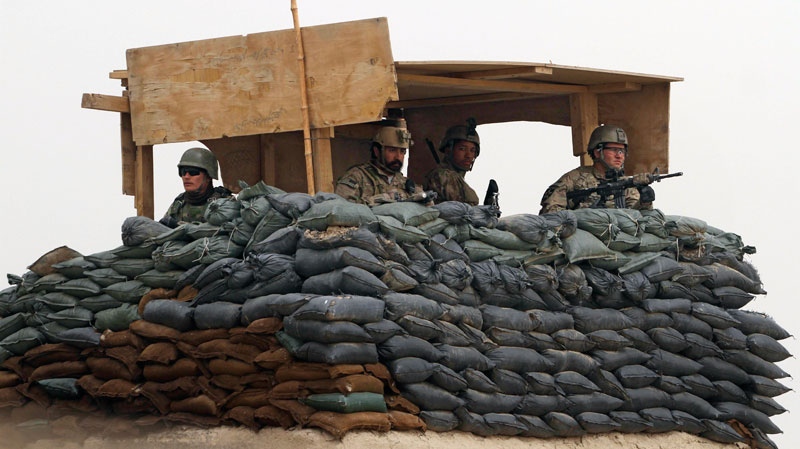In this Sunday, March 11, 2012 file photo, U.S. Army and Afghan soldiers are seen in a guard tower at their base in Panjwai, Kandahar province south of Kabul, Afghanistan. (AP / Allauddin Khan)