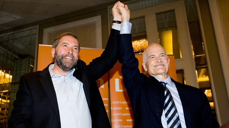 NDP leader Jack Layton, right, takes the hand of deputy leader Thomas Mulcair following his address to members of his Quebec caucus at an NDP convention in Montreal Saturday, May 28, 2011. (Graham Hughes / THE CANADIAN PRESS)
