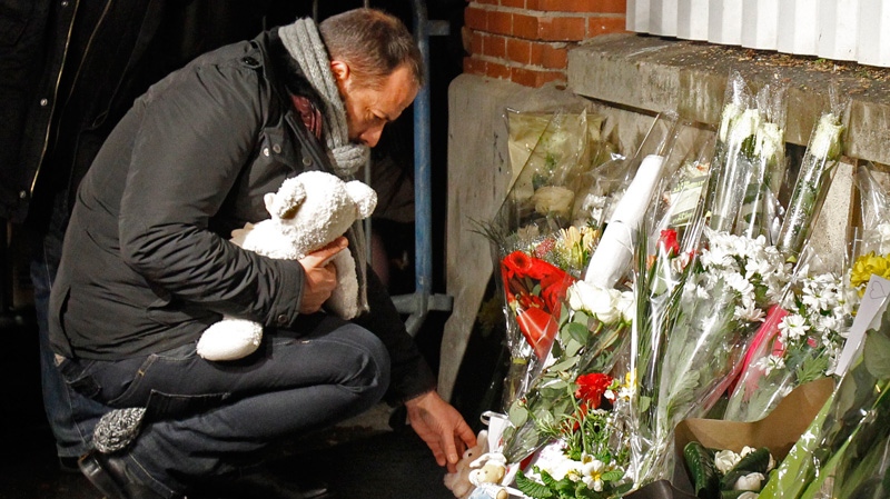 A man puts a teddy bear at a makeshift shrine at the Ozar Hatorah Jewish school where a gunman opened fire killing four people Monday, March 19, 2012 in Toulouse, southwestern France. (AP / Remy de la Mauviniere)