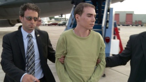 Luka Rocco Magnotta is taken by police from a Canadian military plane to a waiting van on June 18, 2012 in Mirabel, Quebec. (THE CANADIAN PRESS)