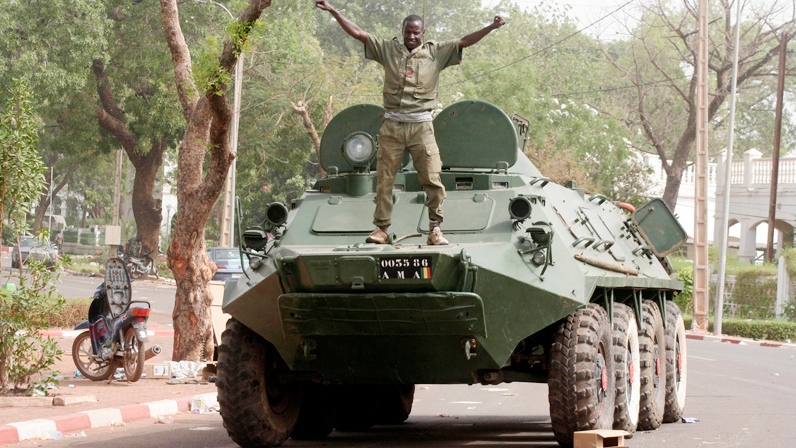 A soldier poses atop a military vehicle, as it stands guard outside the presidential palace following a military coup in Bamako, Mali, Friday, March 23, 2012. (AP / Harouna Traore)